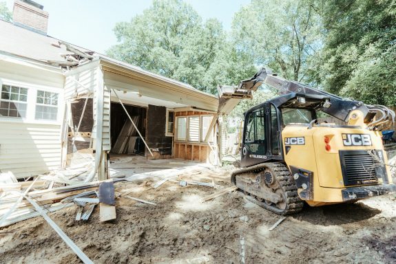 Travaux de construction avec une machine sur un site résidentiel.